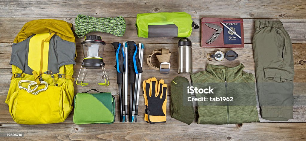 Hiking and camping gear organized on rustic wooden boards High angled view of organized hiking gear placed on rustic wooden boards in rectangle format. Backpack Stock Photo