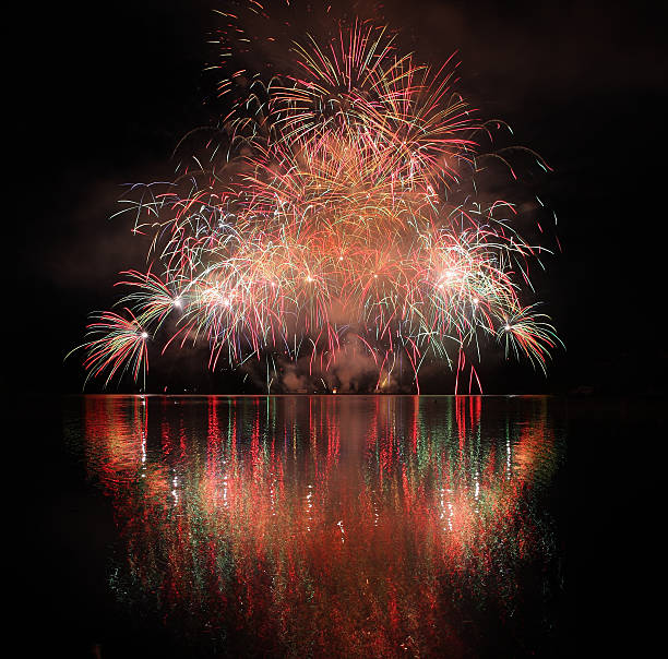 Colorful fireworks with reflection on lake.