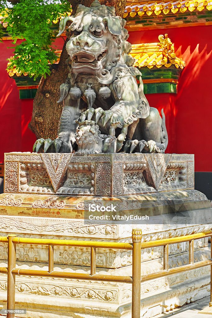 Bronze lion at the entrance to beautiful Yonghegong Lama Temple. Bronze lion at the entrance to beautiful Yonghegong Lama Temple.Beijing. Lama Temple is one of the largest and most important Tibetan Buddhist monasteries in the world. 2015 Stock Photo