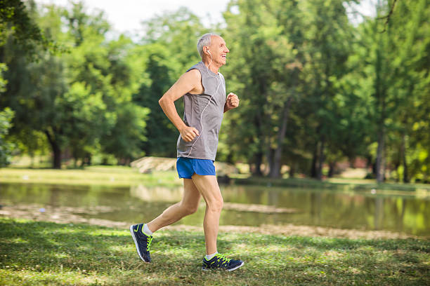 active senior para correr en un parque y escuchar música - full length audio fotografías e imágenes de stock