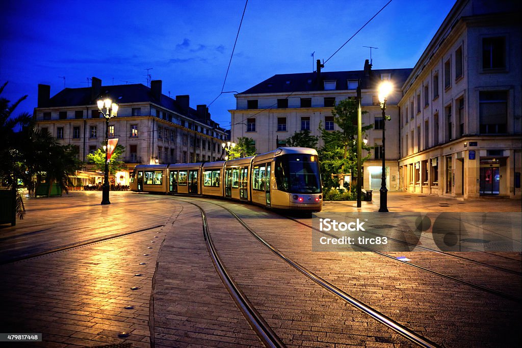 Tram at dusk in Orleans France Tram travelling through cobbled square at dusk in Orleans France Orleans - France Stock Photo