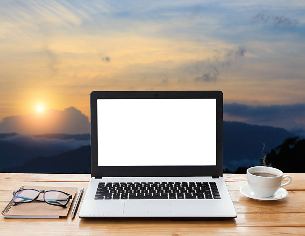 istock laptop and coffee on workspace and mountain at sunset background 479822318