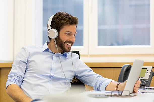 istock Cheerful man listening music and using computer in modern office 479824624