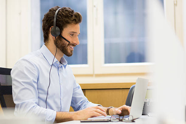Happy Businessman in the office on the phone, headset, Skype stock photo