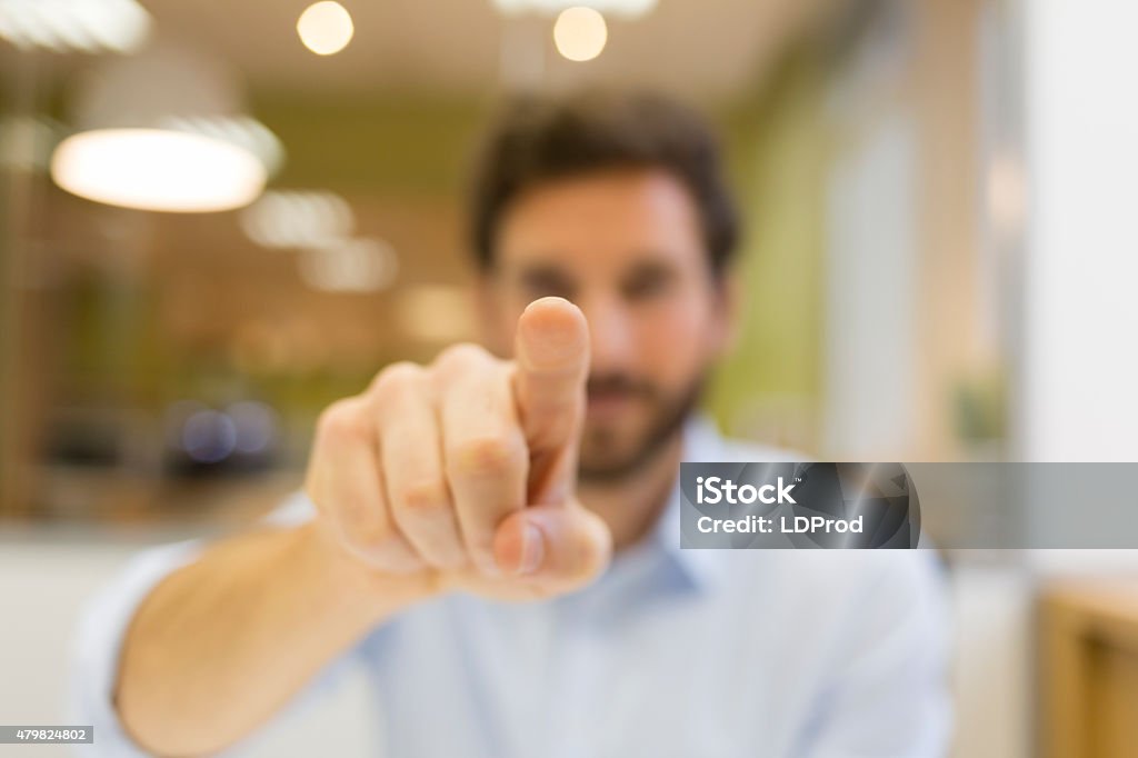 Man hand pushing a digital screen on office background A man pointing his finger on digital touch computer, facing camera Computer Monitor Stock Photo