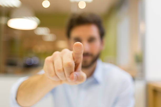 Man hand pushing a digital screen on office background stock photo
