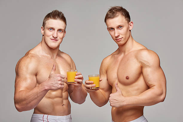 dwa sportowy mężczyzn z szklanki soku pomarańczowego - instructor one person fruit drinking zdjęcia i obrazy z banku zdjęć