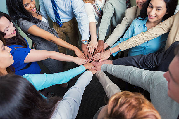 istock Diverse team of business professionals with hands in huddle 479836686