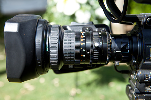 Camcorder Video camera lens detail over green background