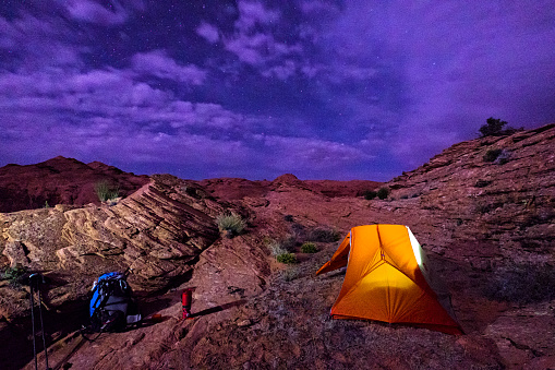 Backpacking Under the Stars - Tent lit up with stars in desert canyons in Southwest Utah USA.