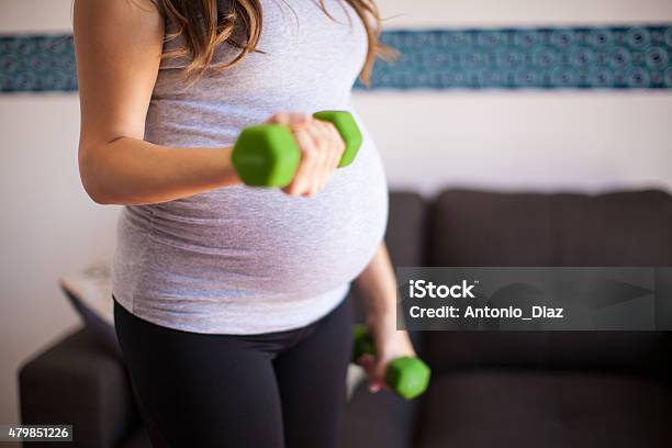 Pregnant Woman Lifting Weights Stock Photo - Download Image Now - 20-29 Years, 2015, Active Lifestyle