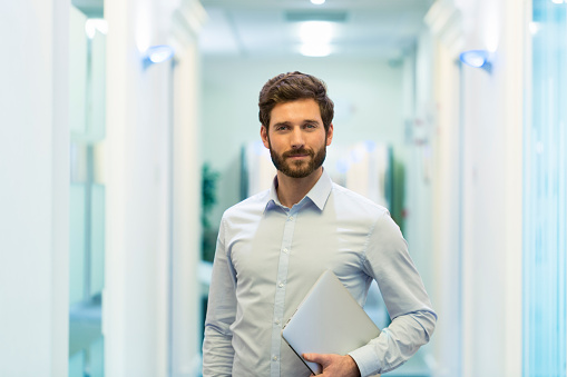 Business man hipster style with laptop in office. looking at camera