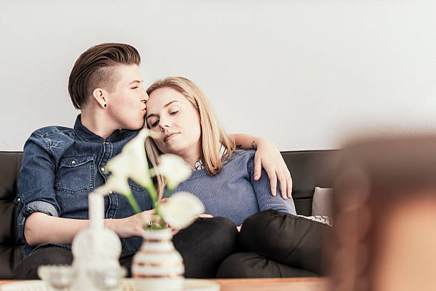 istock Romantic lesbian couple sitting on sofa 479855898