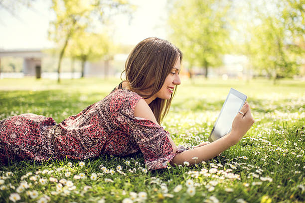 Smiling woman using electronic organizer at the park.