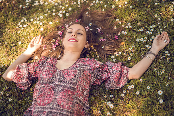 istock Smiling woman day dreaming during spring day in grass. 479875562