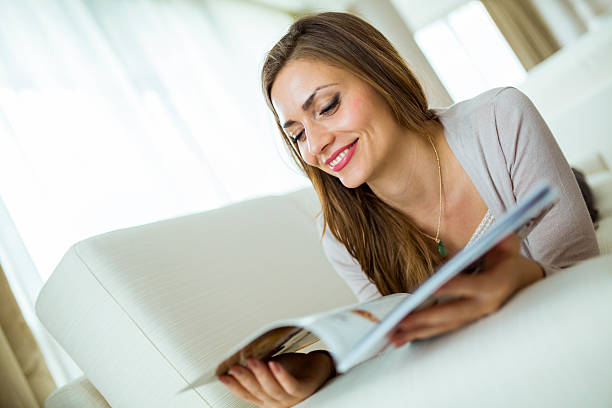 istock Beautiful woman on a sofa reading a paper in room 479876140