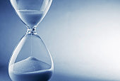 Hourglass clock on light blue background