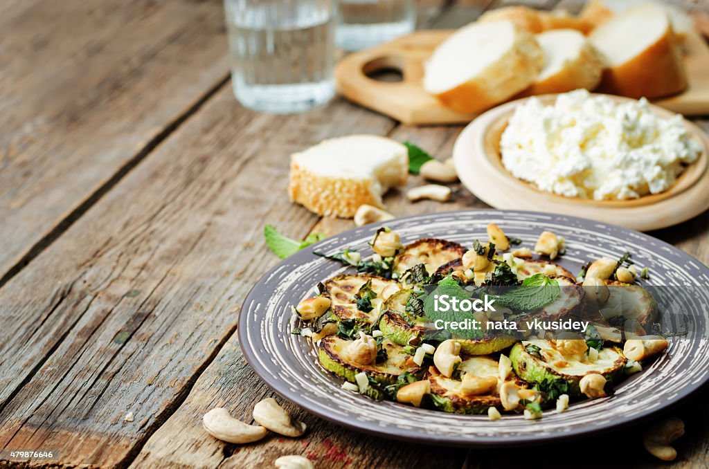 zucchini Basil mint cashews salad with ricotta and fresh bread zucchini Basil mint cashews salad with ricotta and fresh bread. the toning. selective focus Cashew Stock Photo