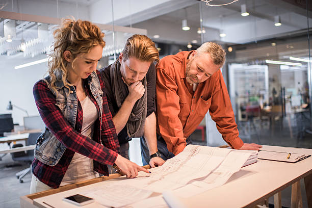 istock Architects working together on blueprints in the office. 479876674