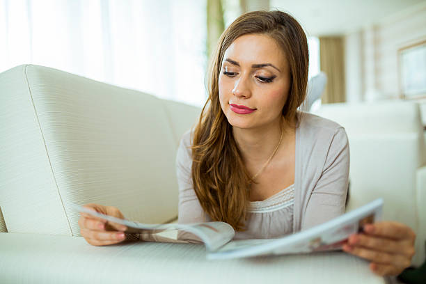 istock Beautiful woman reading a paper in the living room 479876708