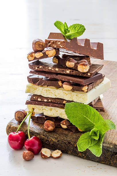 istock Different kinds of chocolate, nuts, berry, mint, white wood background 479877268