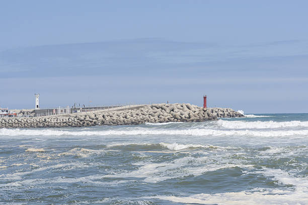 Gangneung port with strong ocean waves after the summer rain, The view of light house taken from Namjangjin beach