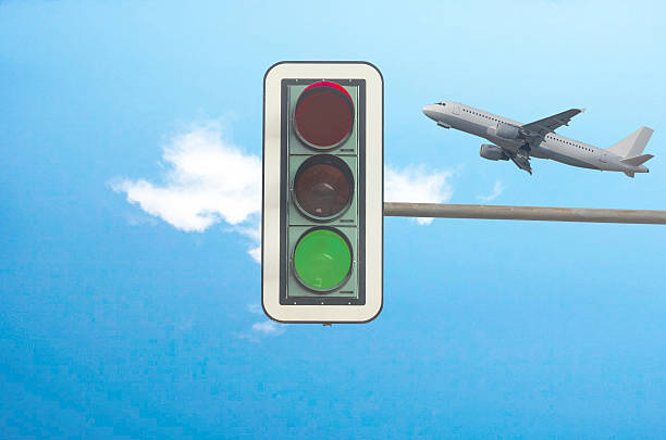Green traffic light, airplane in background stock photo