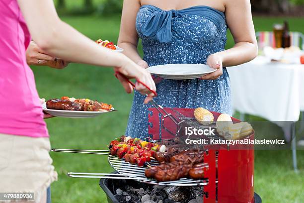 Host Serving Meals On Barbecue Party Stock Photo - Download Image Now - 2015, Adult, Barbecue - Meal