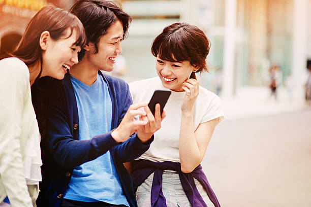 gruppe von jungen mit smartphone japanischen personen - photographing smart phone friendship photo messaging stock-fotos und bilder