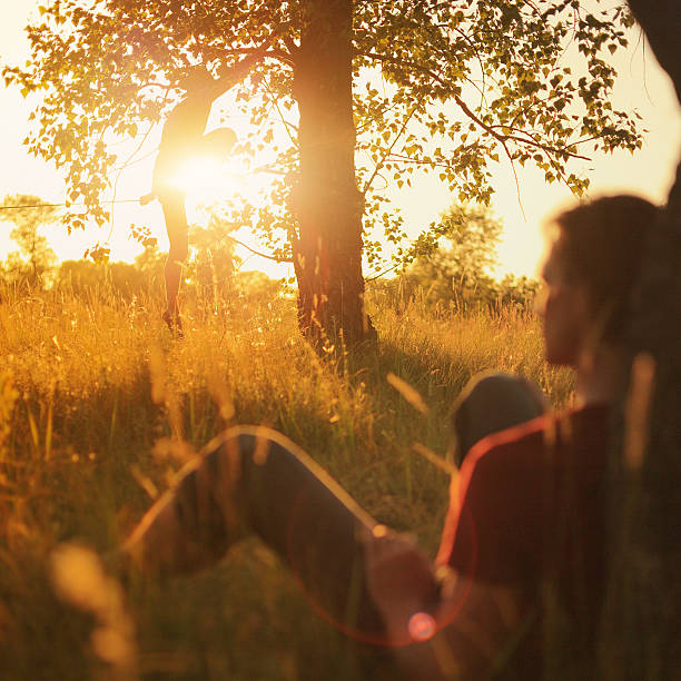 istock Man walking on slackline in the meadow at sunset. 479883382