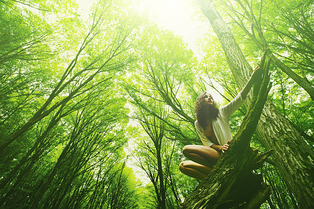 A Young Woman is Showing a Natural Love by Embracing a Forest Tree.