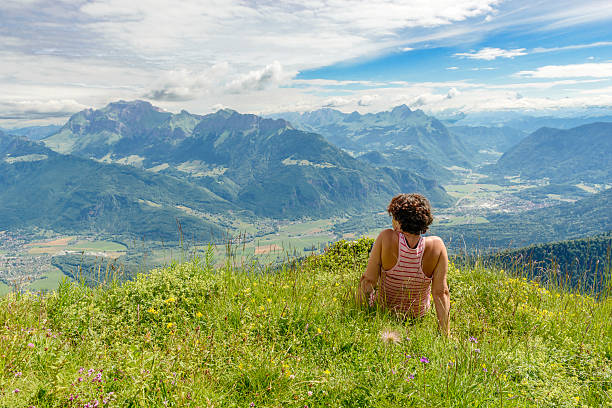 istock woman sitting on cliff and  looking at landscape 479883990