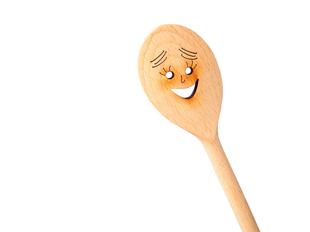 A smiling face painted on a wooden spoon.