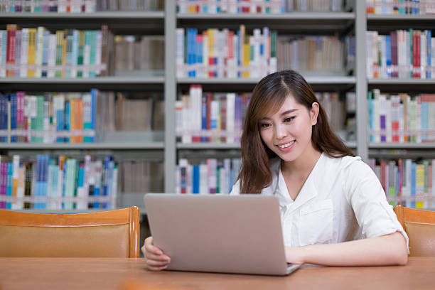 istock Beautiful asian female student using laptop for study in library 479893752