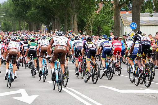 Gouda, The Netherlands – July 5, 2015: Rear view of the Tour de France peleton riding past Gouda. In 2015 The Netherlands hosted two first stages in the city of Utrecht; the second day race started in Utrecht and passed through Gouda to the province Zealand. 