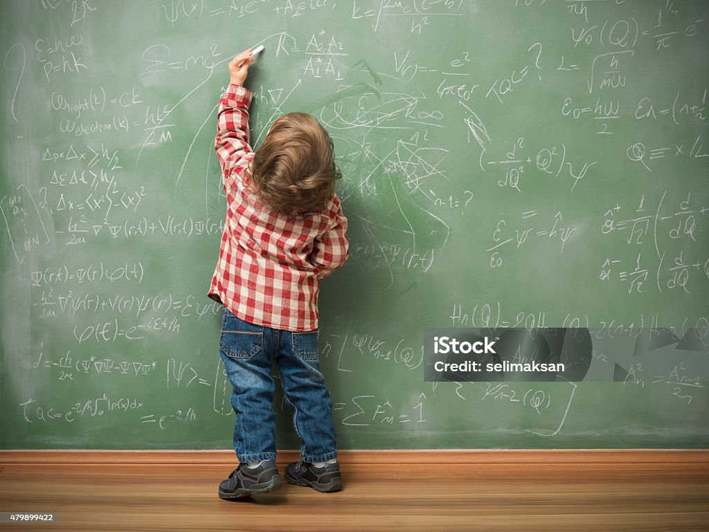 Petit garçon écrit sur le tableau noir vert - Photo de Gaucher libre de droits