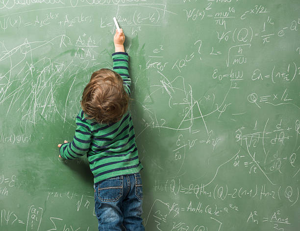 istock Little boy writing on green blackboard 479899570