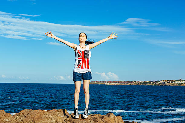 menina na praia com os braços esticados - arms outstretched teenage girls jumping flying imagens e fotografias de stock