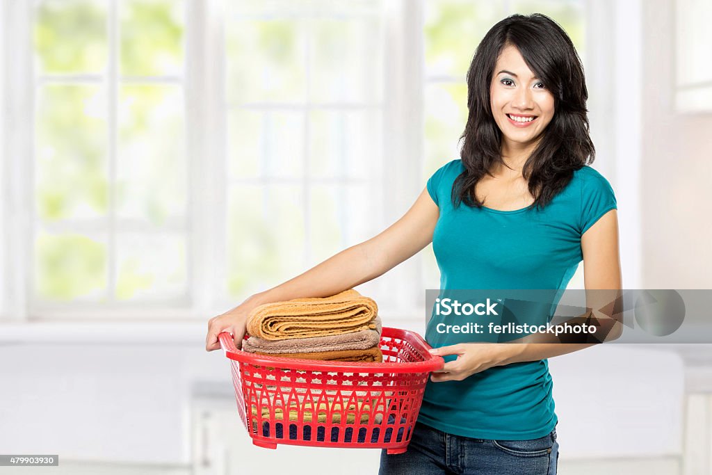 woman with laundry woman doing a housework holding laundry in the house 2015 Stock Photo