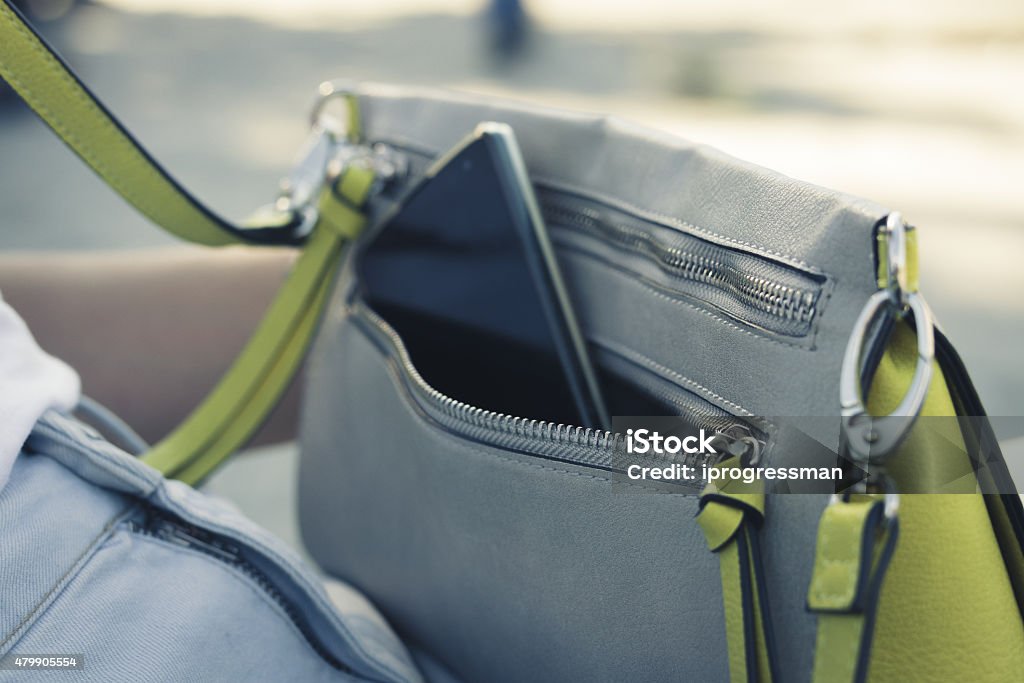 Women's handbag with the phone on the street close up Purse Stock Photo