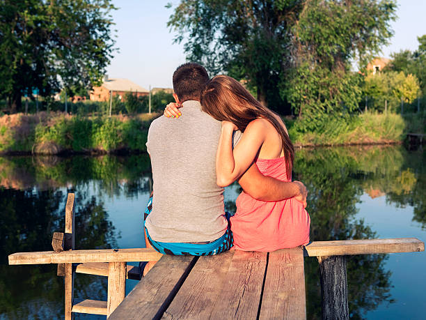 istock young couple sitting embracing on the bridge by the river 479909298