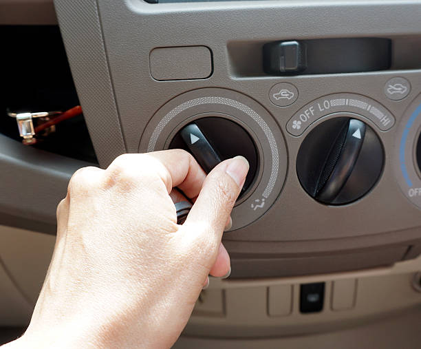 istock Female driver turning car air conditioner knob 479909992