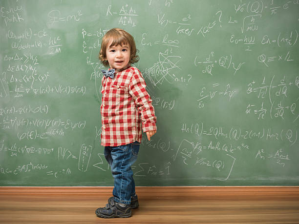 istock Little boy standing in front of green blackboard 479913148