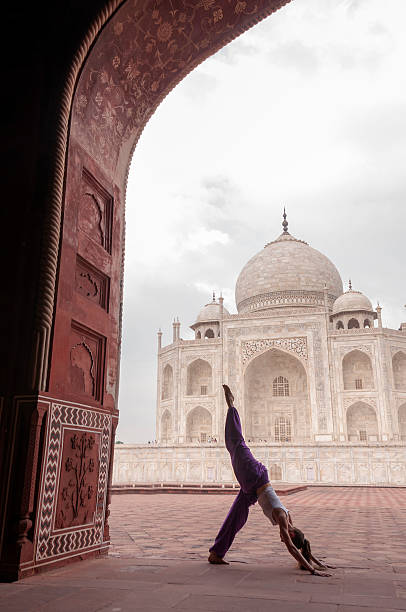 istock Young female practising yoga pose at Taj Mahal 479913194