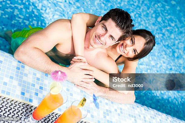 Couple Drinking A Cocktail By The Swimming Pool And Relaxing Stock Photo - Download Image Now