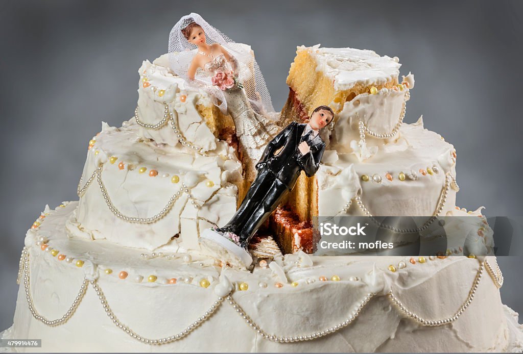 Bride and groom figurines collapsed at ruined wedding cake Spouses always seem to struggle to keep their relationship alive Wedding Stock Photo