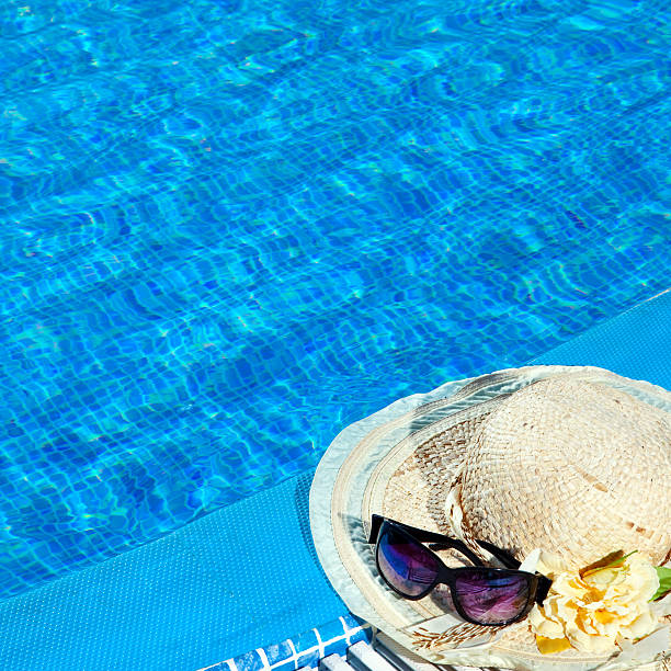 istock The straw hat and sunglasses lie near  pool 479916894