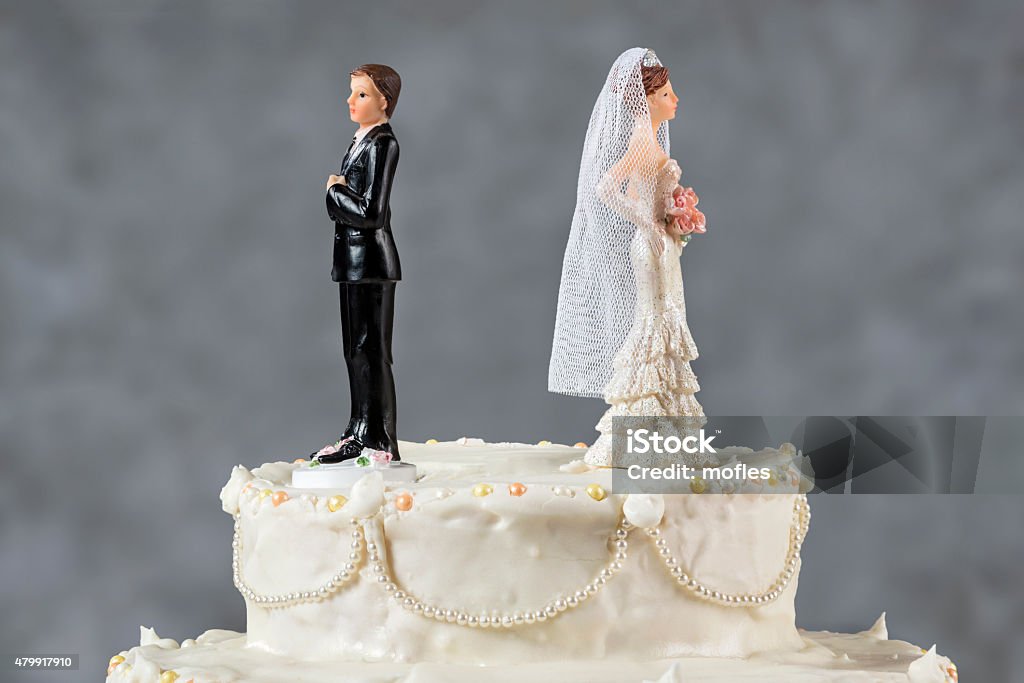 Spouses having their first disagreement Wedding cake spouses turning their backs to each other for emerging problems Divorce Stock Photo