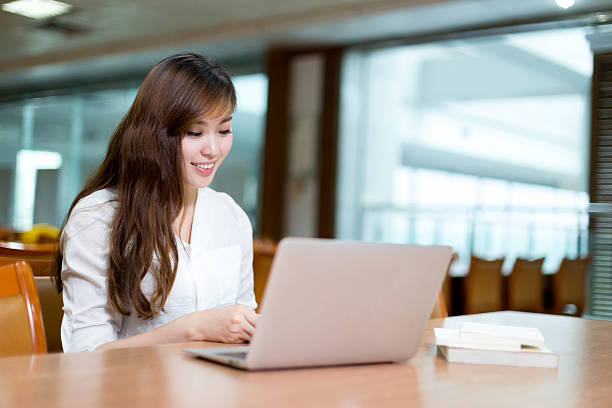 istock Beautiful asian female student using laptop for study in library 479918288