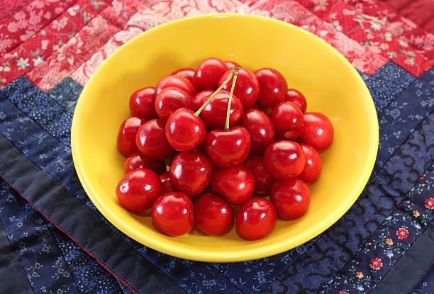 Ripe juicy cherries in a yellow plate